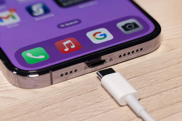 Крупный план: iPhone заряжается с помощью кабеля USB-C.